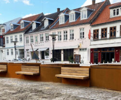 områdefornyelse af Mathilde Fibgers Have i Aarhus med By Bangs plantekummer i cortenstål med bænke monteret på sider, som er beklædt med mahogni planker