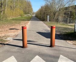 to corten pullerter med røde reflekser på stien
