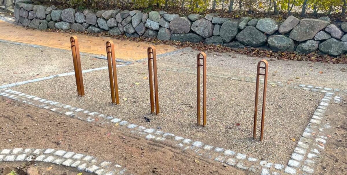 en række af elegante cykelstander i corten stål med plads til en cykel til by og park