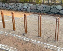 en række af elegante cykelstander i corten stål med plads til en cykel til by og park