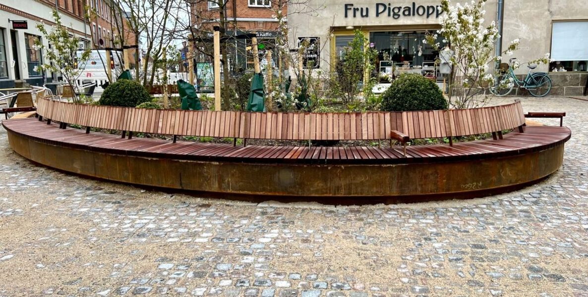 Hillerød møbler, corten bænk med mahogni sæder og ryg, blomsterbed i indercirkel