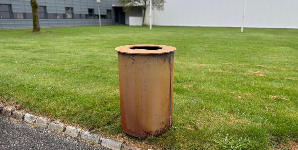 Skraldespan i rusten stål i parken