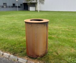 Skraldespan i rusten stål i parken