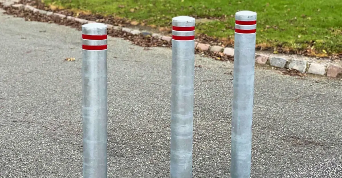 tre almindelige pullerter i galvaniseret stål og med røde reflekser