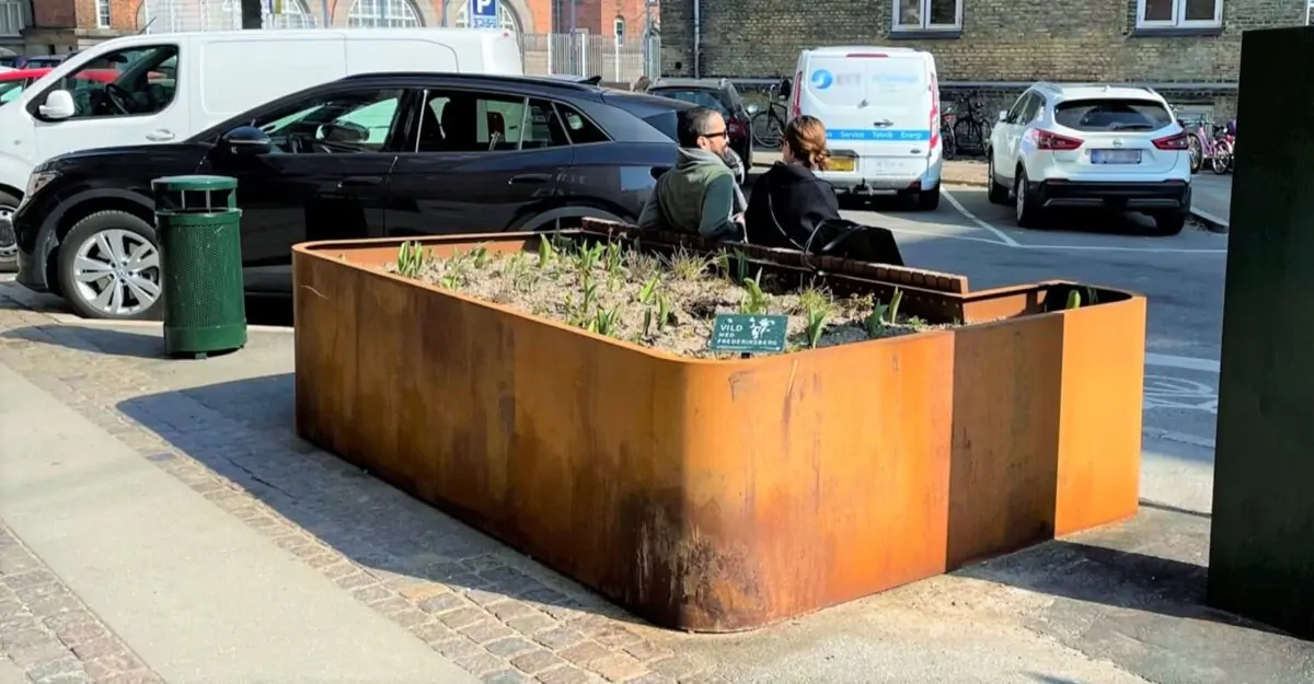 en unik plantekasse i cortenstål med en bænk af mahogni planker på Frederiksbergs gade