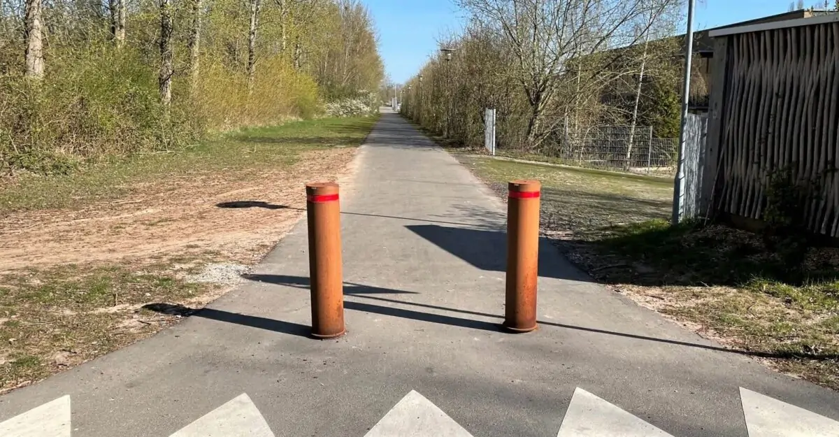 to corten pullerter med røde reflekser på stien