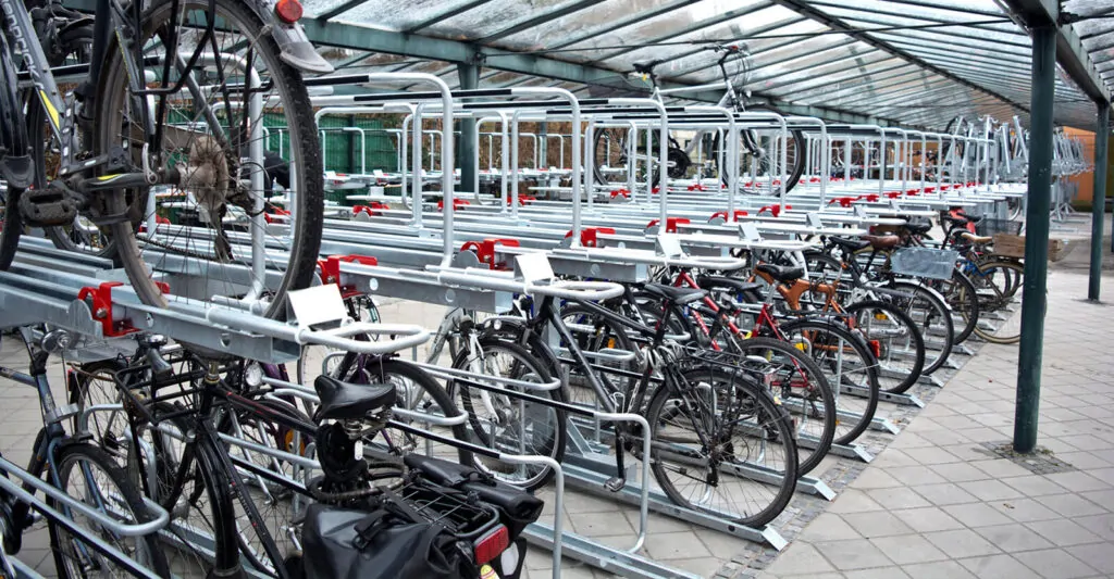 en stort dobbelt cykelparkering under overdækning med cykelstativer i to etager