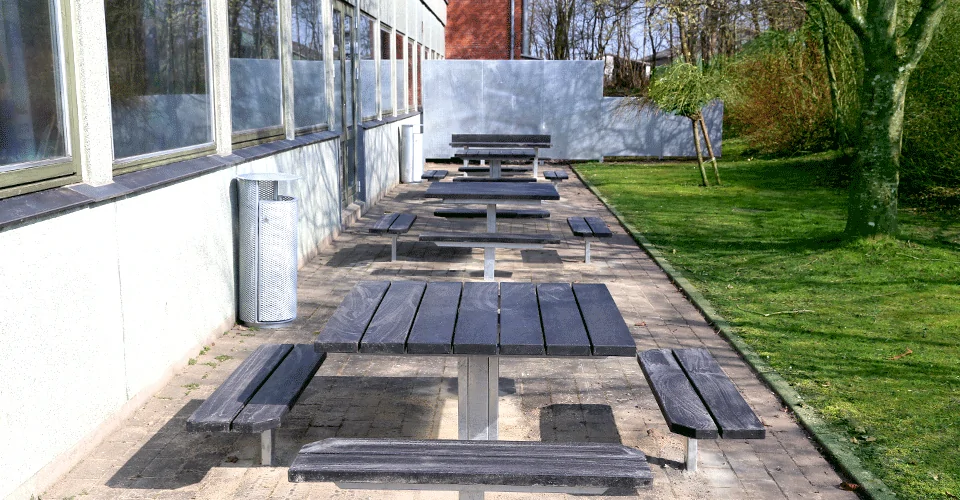udendørs bordbænksæt i galvaniseret stål og beklædt med genbrugsplastplanker på række fra BY BANG
